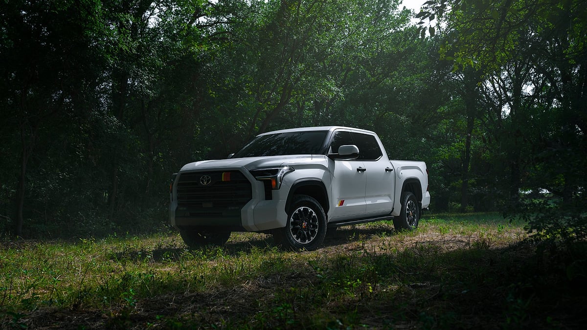 White Toyota Tundra TRD Rally pickup parked on a shaded forest trail.