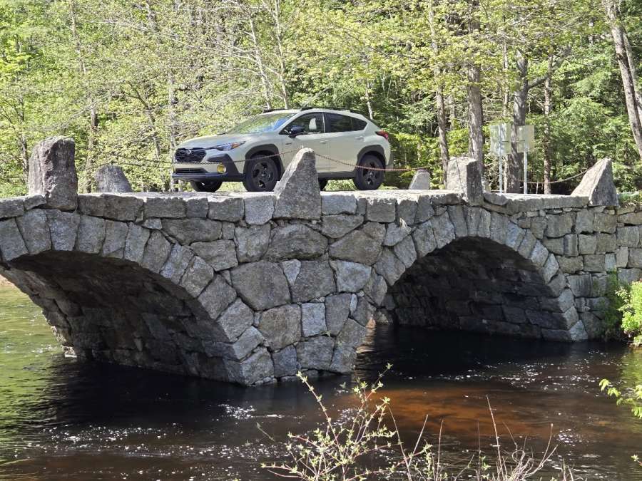 26 Subaru Crosstrek Hybrid crosses a stone arch bridge