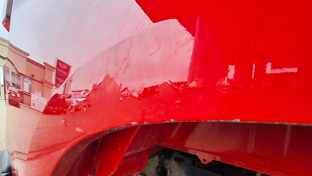 A 2024 Chevy Silverado showing severe paint peel on the front fender at only 28,000 miles in Canada