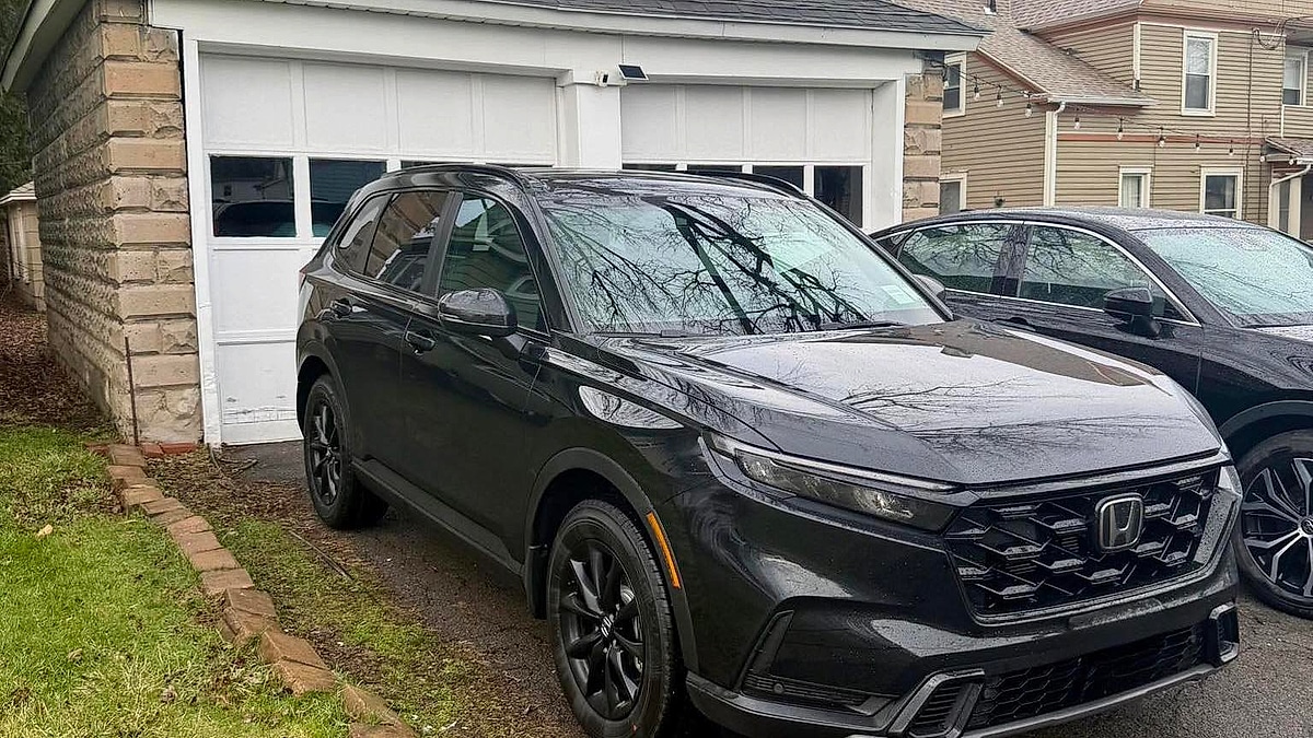 A 2026 Honda CR-V Hybrid Sport-L, a sleek black SUV, sits parked in Tyler Kisacky's residential driveway on a cloudy day