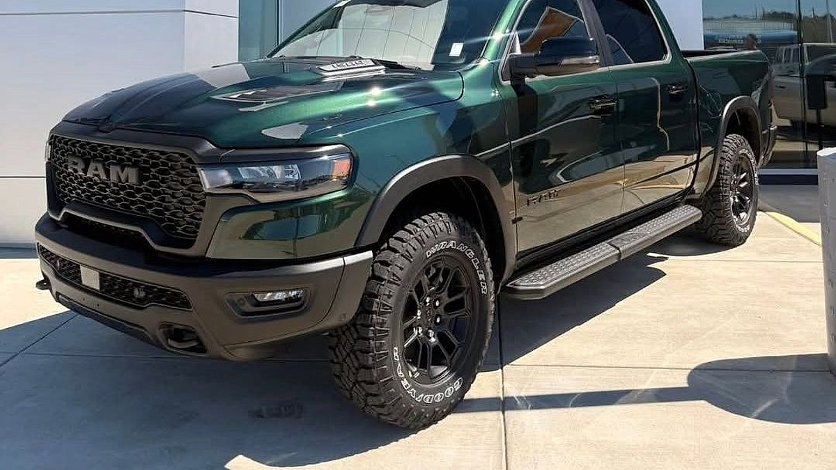 A 2026 Timberline Green Ram 1500 pickup parked in front of the Ram dealer