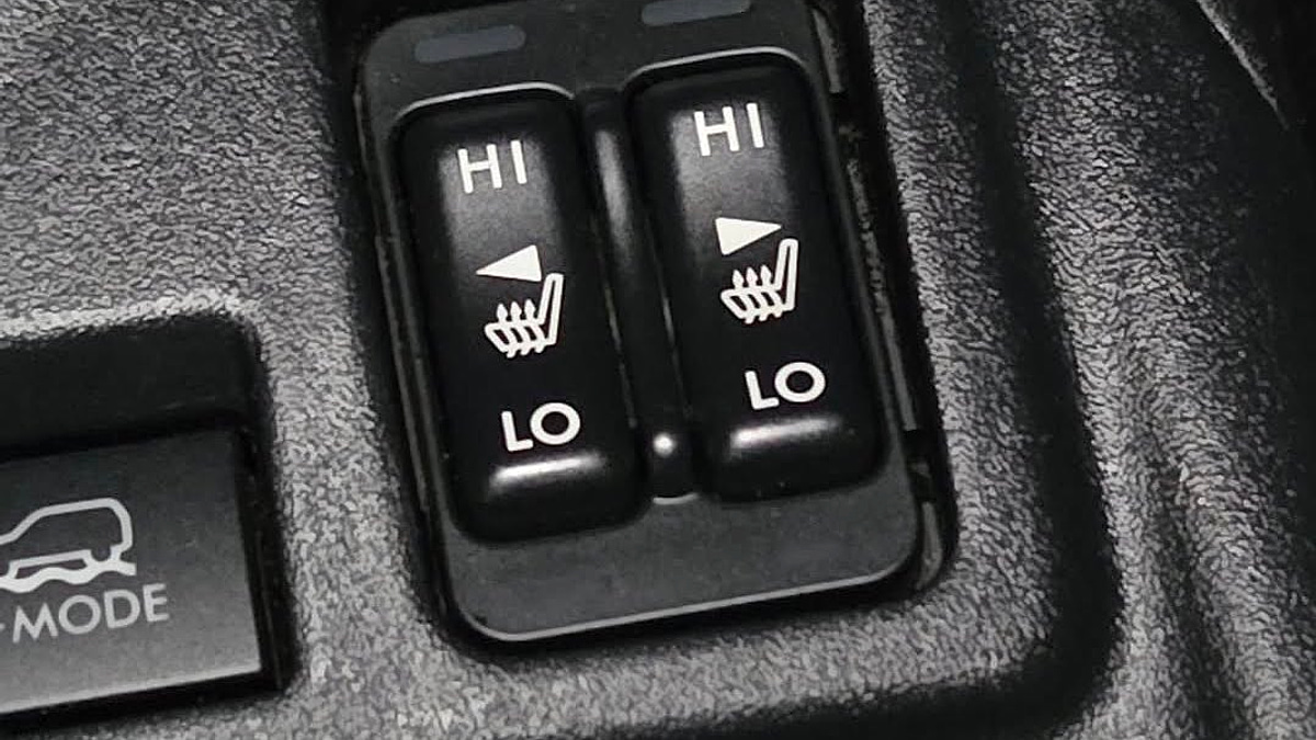 A close-up photograph of a 2025 Honda CR-V center console, focusing on the heated seat button, which is clearly switched to the off position, with all three indicator lights dark