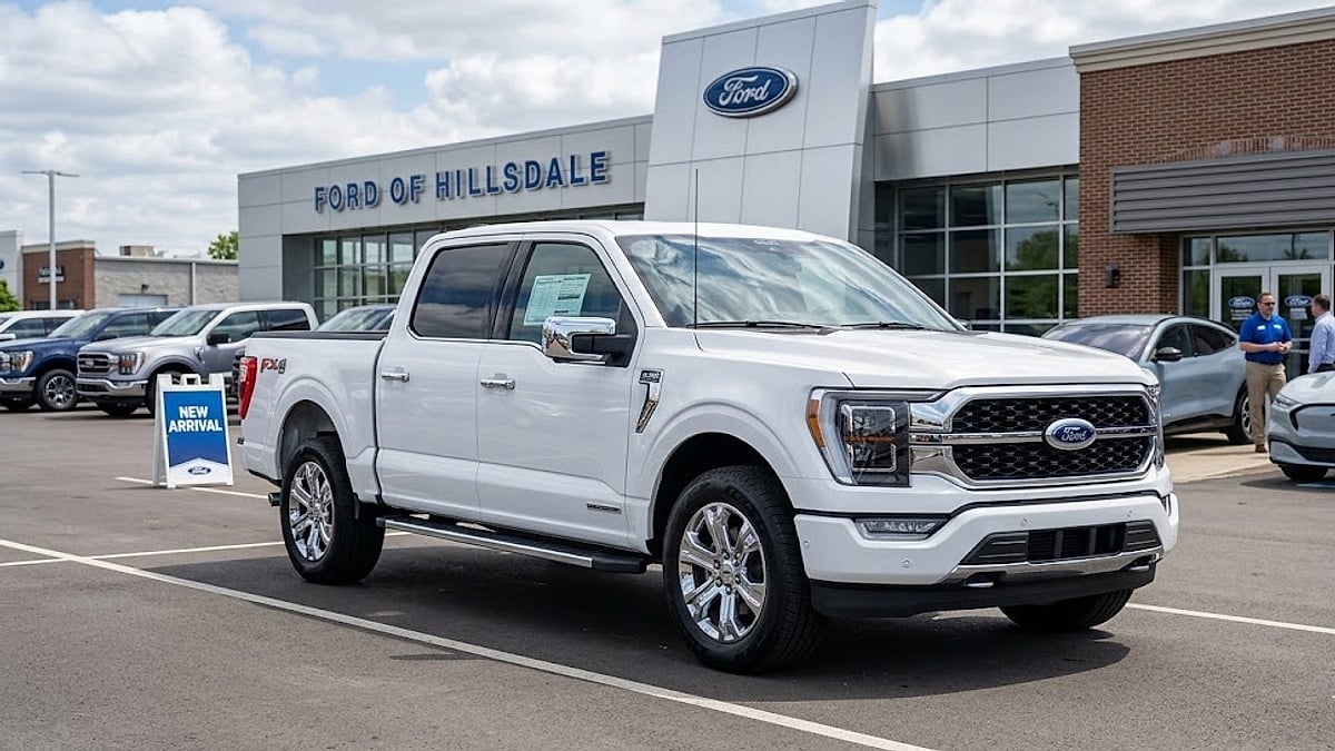 A pristine white Ford F-150 Lariat, featuring 'FX4' badging, parked at a Hillsdale, Alabama dealership on a clear day
