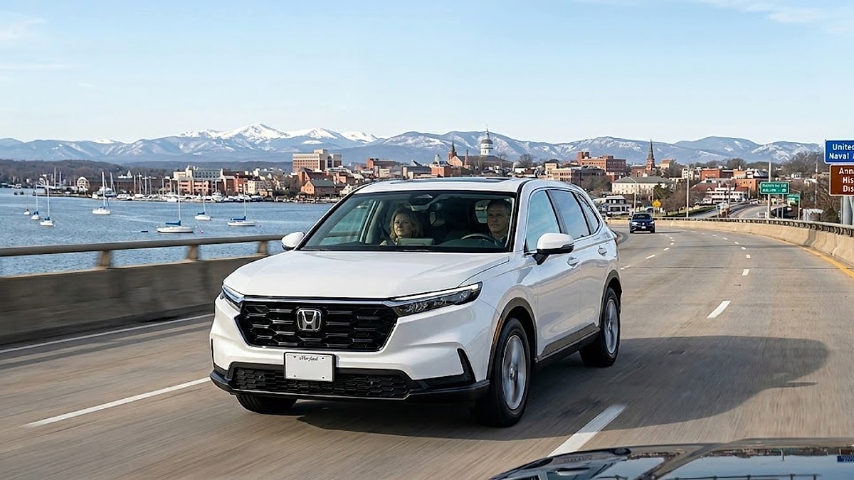 A white Honda CR-V travels a Maryland highway, with Annapolis landmarks and the Naval Academy visible, and distant mountains under clear skies-optimized