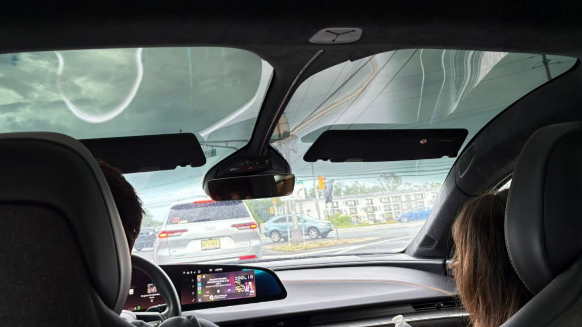 Two passengers in the front seat of a Lucid Air, appearing comfortable and engaged with each other