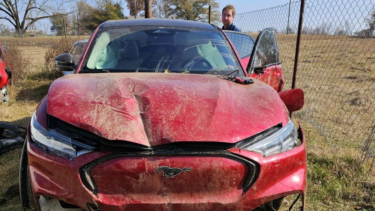 Eric with his red Ford Mustang Mach-E which isn't much damaged after the wreck