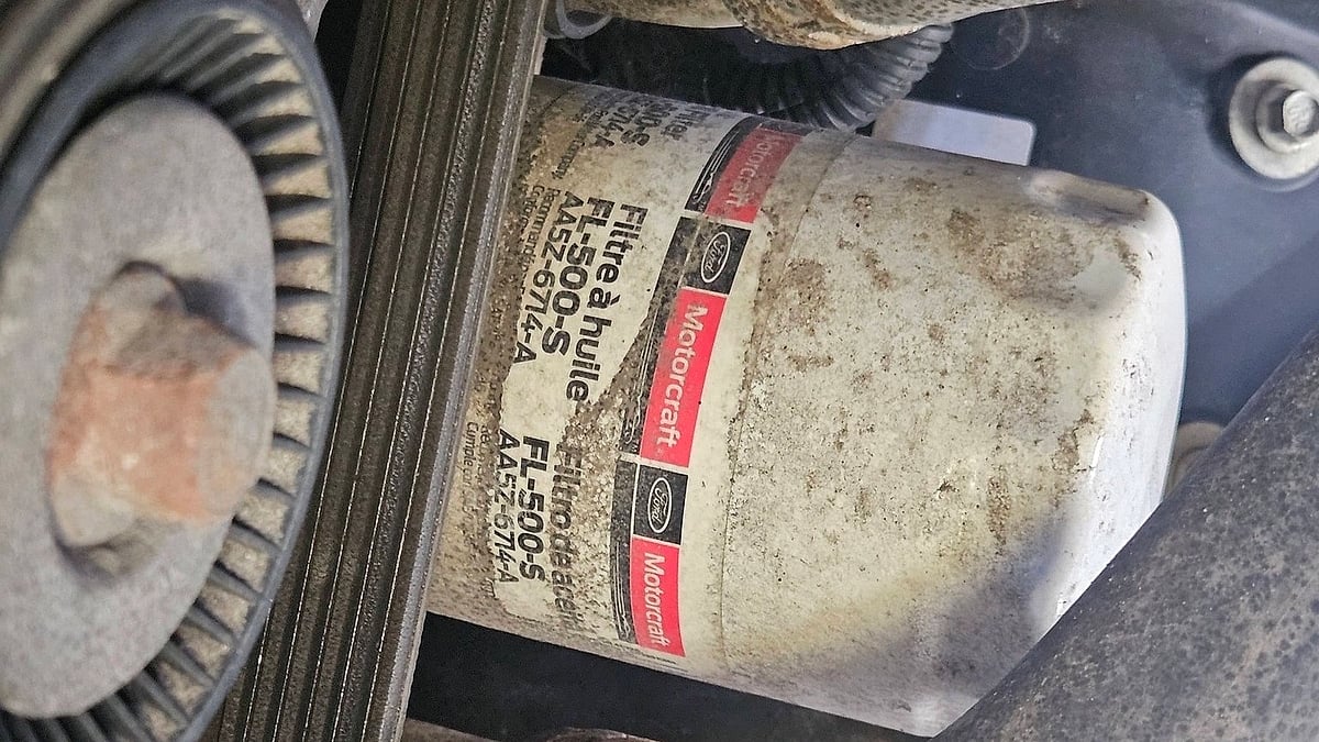 F-150 owner in Waterloo shows his  5.0L engine dirty oil filter after a dealership service package shortcut