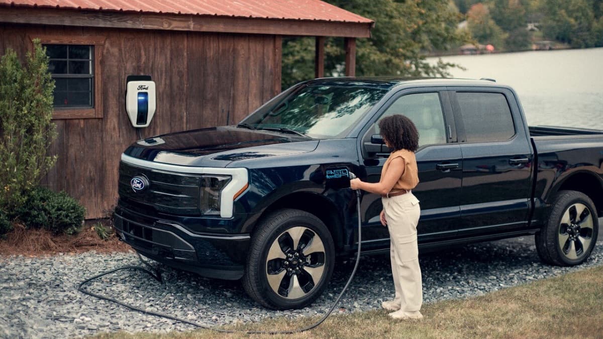 Ford F-150 Lightning being charged by a woman