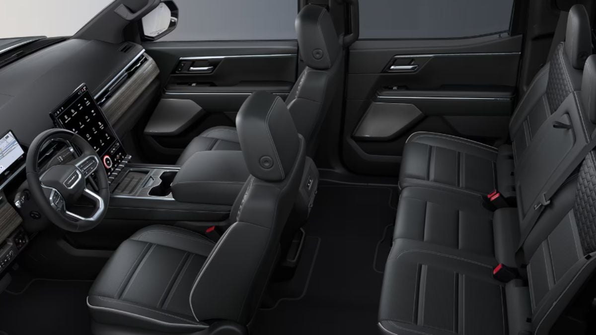 Luxurious Sierra EV interior with black leather seats, sleek dashboard, and modern touchscreen display. The spacious design conveys a sense of comfort