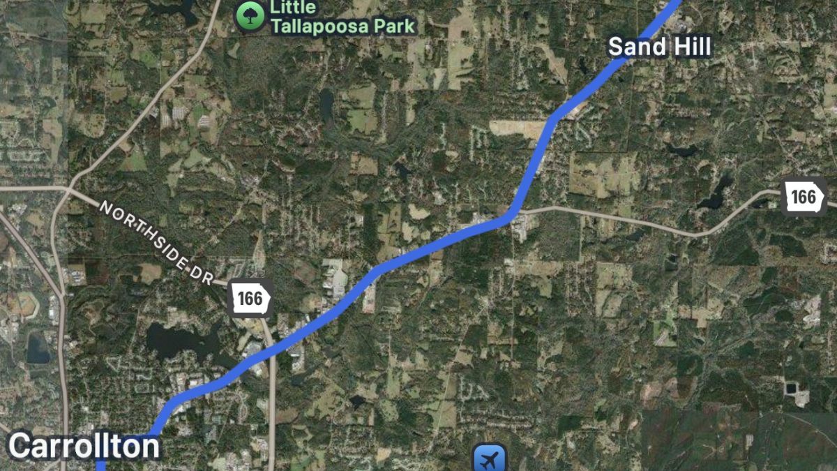 A map showing a route marked in blue from Carrollton to Sand Hill in Georgia. The map displays roads, greenery, and landmarks like Little Tallapoosa Park.