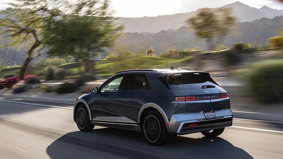 Hyundai Ioniq 5 electric SUV driving through a suburban neighborhood rear view