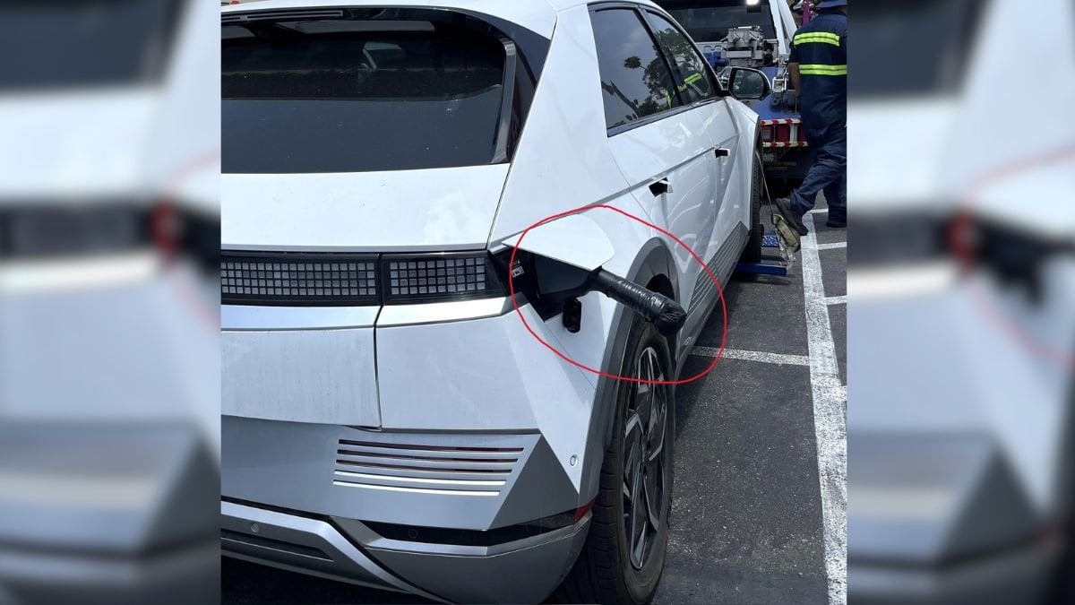 A white electric vehicle parked with a charging port visible, showcasing modern design and unique rear features.