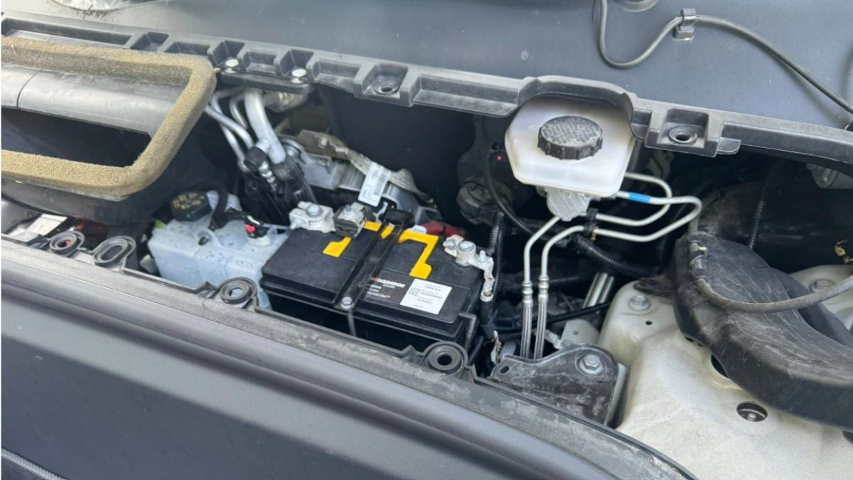 View of the battery compartment inside the frunk of a Tesla Model Y, highlighting key interior components