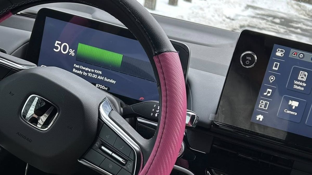 Interior dashboard view of Ashley's Honda Prologue showing the digital display at 50% charge status with a pink/burgundy steering wheel wrap and the Honda logo visible on the steering wheel.