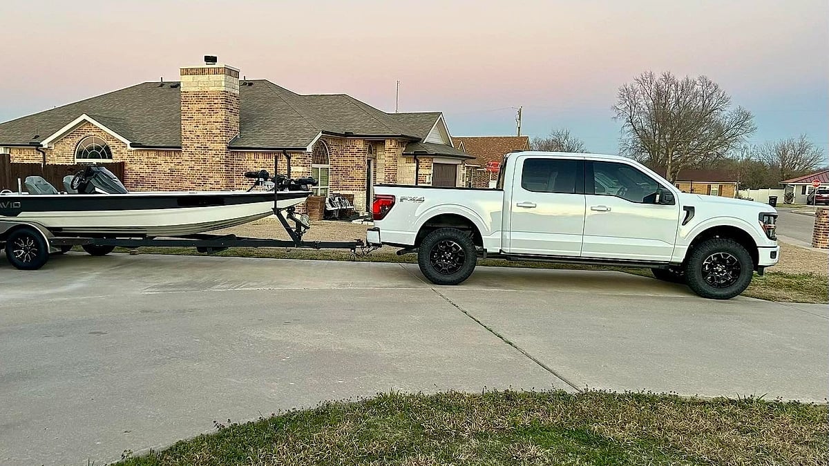 Jon Clark's white 2025 Ford F-150 towing a small fishing boat parked in his home in Texas