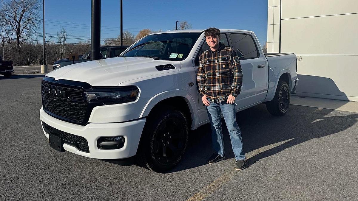 Joshua Barker from Watertown NY standing by his new truck at the dealer