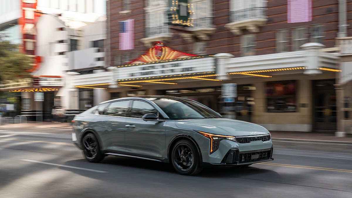 Kia K4 driving through city street with motion blur background