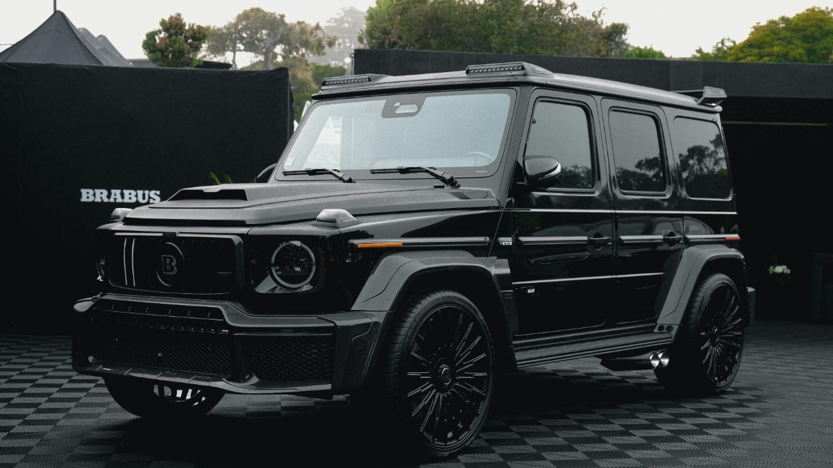 A black Brabus-modified Mercedes-Benz G-Class SUV shown from a front three-quarter angle, featuring custom wheels, LED lighting, and aggressive body styling with carbon fiber accents.