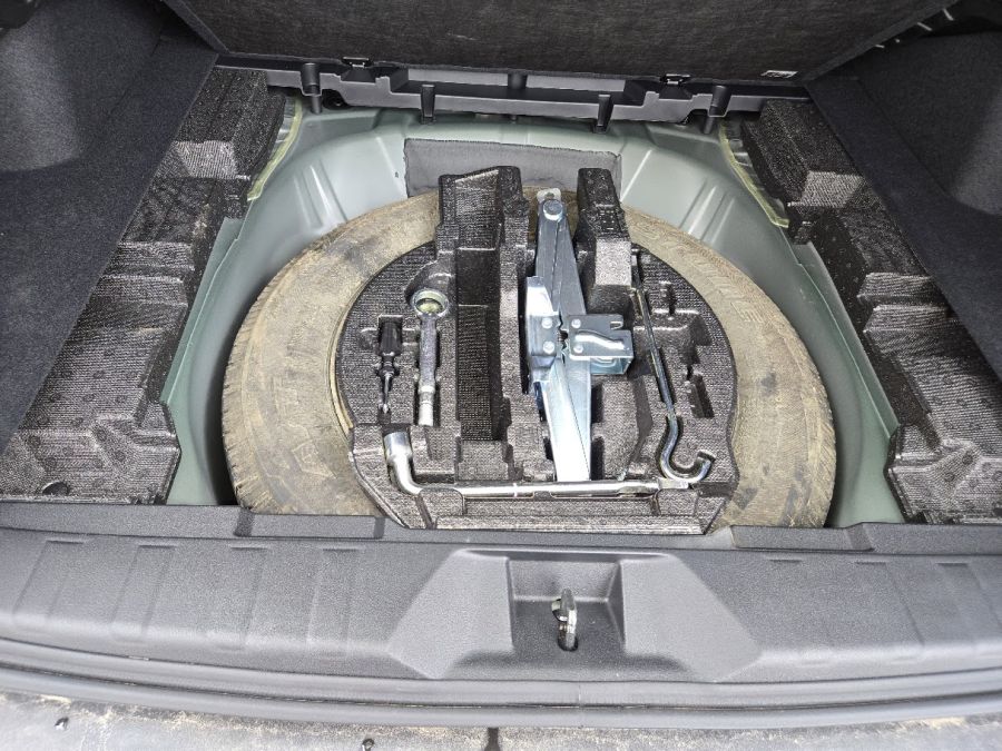A muddy spare tire inside a Subaru Outback