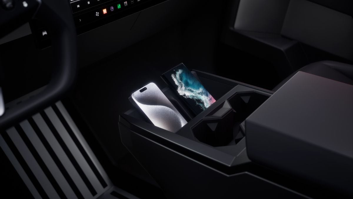 Two smartphones are placed upright in a Tesla Cybertruck's center console. The console is designed with sharp, angular lines, creating a futuristic ambiance.