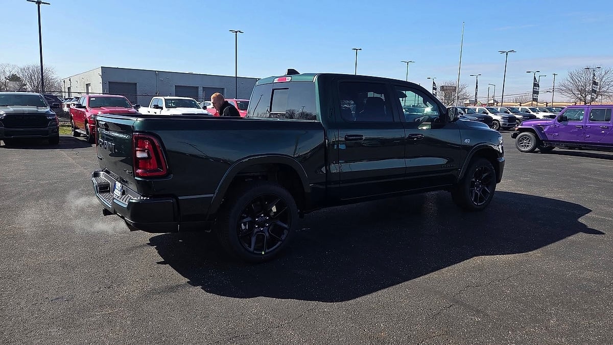 Rear view of a 2026 Timberline Green Ram 1500 pickup parked in the lot of the Ram dealer