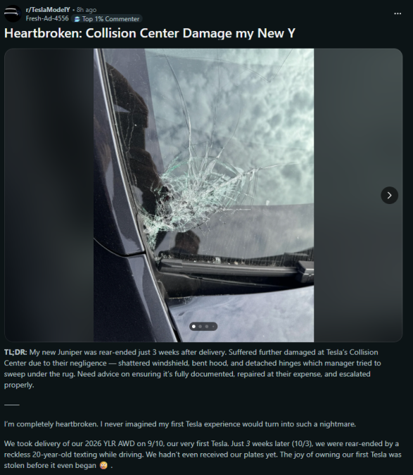 A close-up of a damaged windshield on a dark vehicle, featuring a large crack and shattered glass, reflecting a cloudy sky.