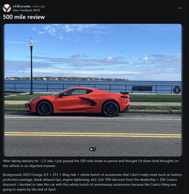 A bright orange 2025 Corvette parked by a scenic waterfront, featuring a blue sky with clouds and a railing in the background.