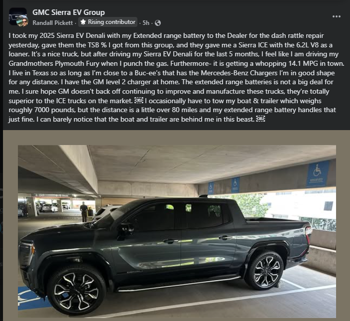 Side view of a dark gray GMC Sierra EV Denali electric pickup truck parked in a covered parking garage, showcasing the full-size electric truck design, wheels, and extended cab.