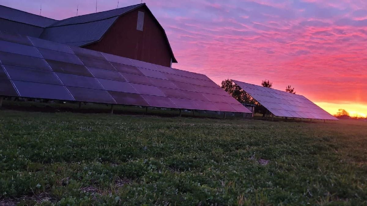 Free standing solar power system in front of a barn.