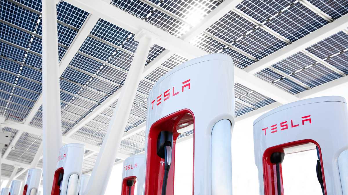 Tesla charging stations with sleek design under a solar panel canopy, promoting sustainable energy and electric vehicle charging.