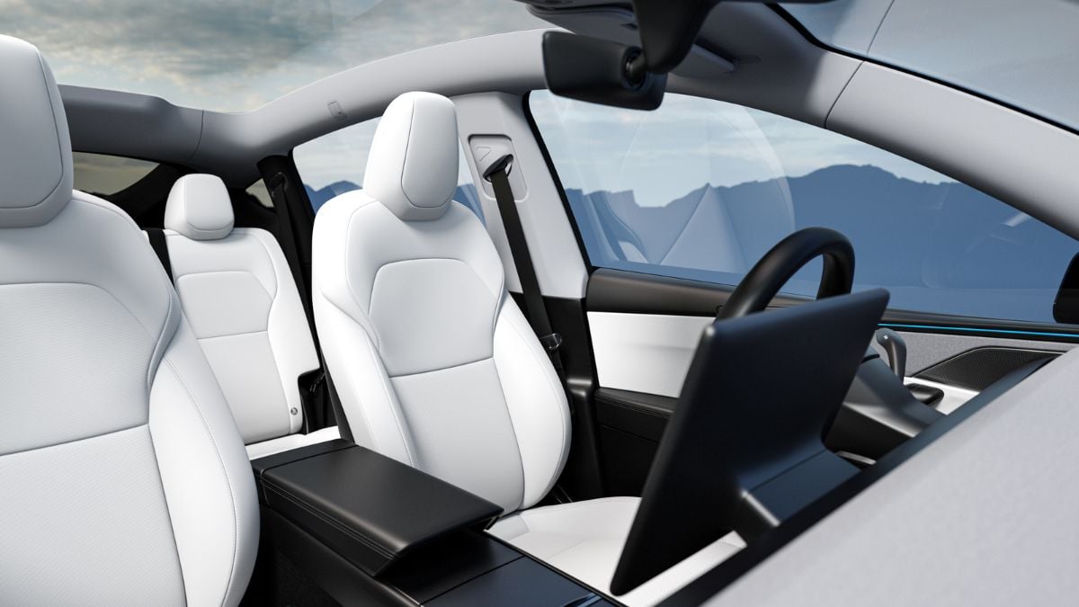 A Tesla Model Y interior with white leather seats and a panoramic sunroof. A large touchscreen is prominently displayed, conveying modernity and luxury.