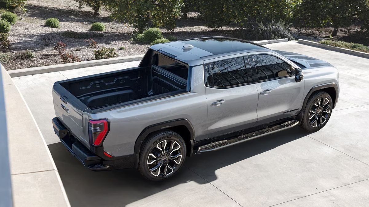 A sleek gray GMC Sierra EV pickup truck parked in a modern outdoor setting, showcasing its stylish design and spacious truck bed