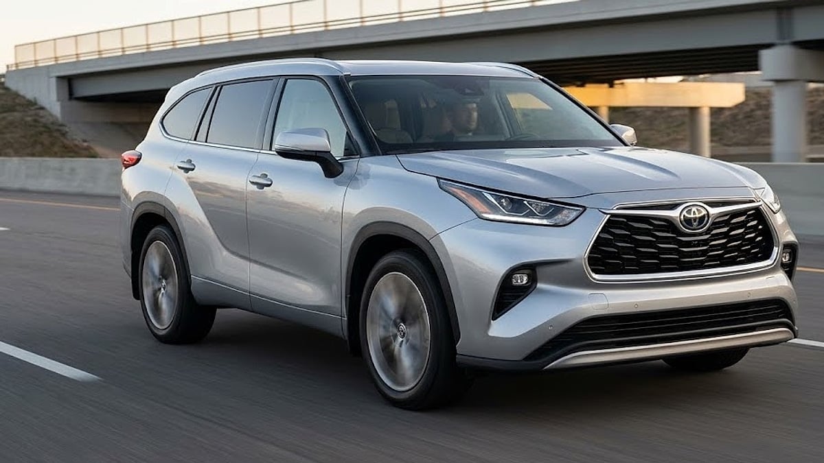 A 2021 Toyota Highlander Platinum accelerates smoothly on a highway, undergoing dynamic on-road testing to analyze real-world cabin refinement