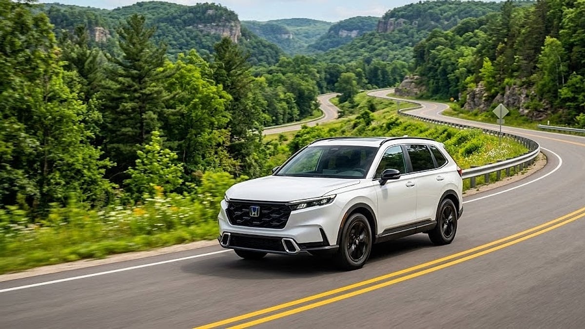 A 2025 Honda CR-V Hybrid navigates a mountain highway in Iowa, highlighting its smooth suspension and low, car-like seating profile