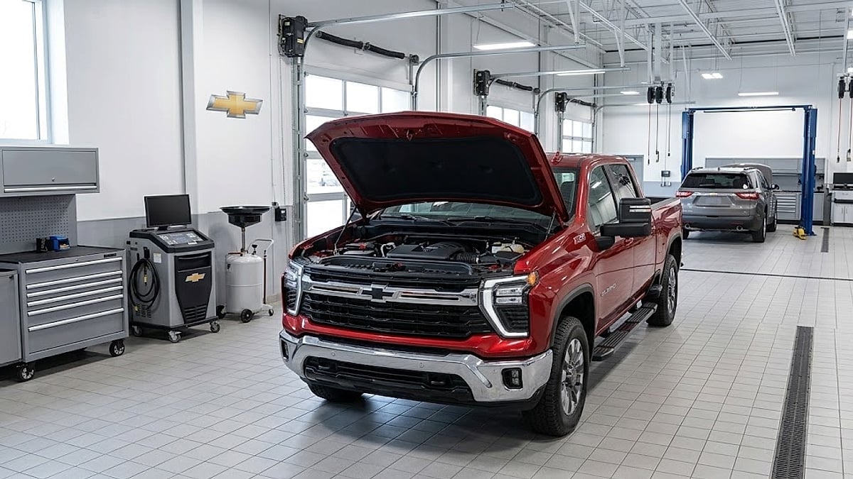 A 2026 Chevrolet Silverado with it’s hood up parked in a modern Chevy dealer’s service bay