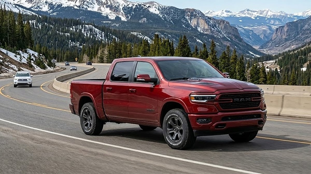 A 2026 Ram 1500 truck with precise tires navigates a winding mountain pass highway, displaying high-altitude performance capabilities on Colorado