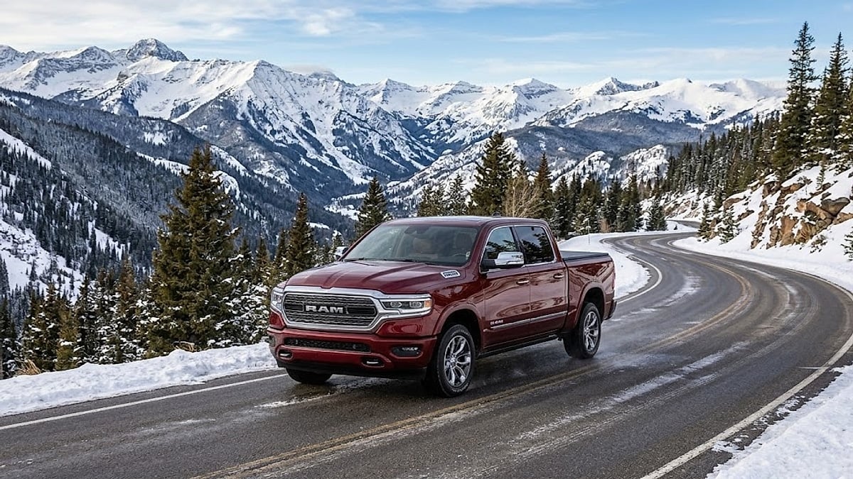 A 2026 Ram Limited Longhorn pickup truck drives along a winding road through the snow-capped Colorado mountains