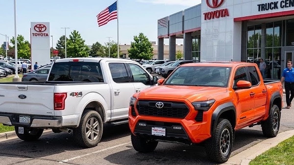 A 2026 Toyota Tacoma TRD parked alongside a traded-in Ford F-150 on a dealership lot, showcasing the midsize track-width offset