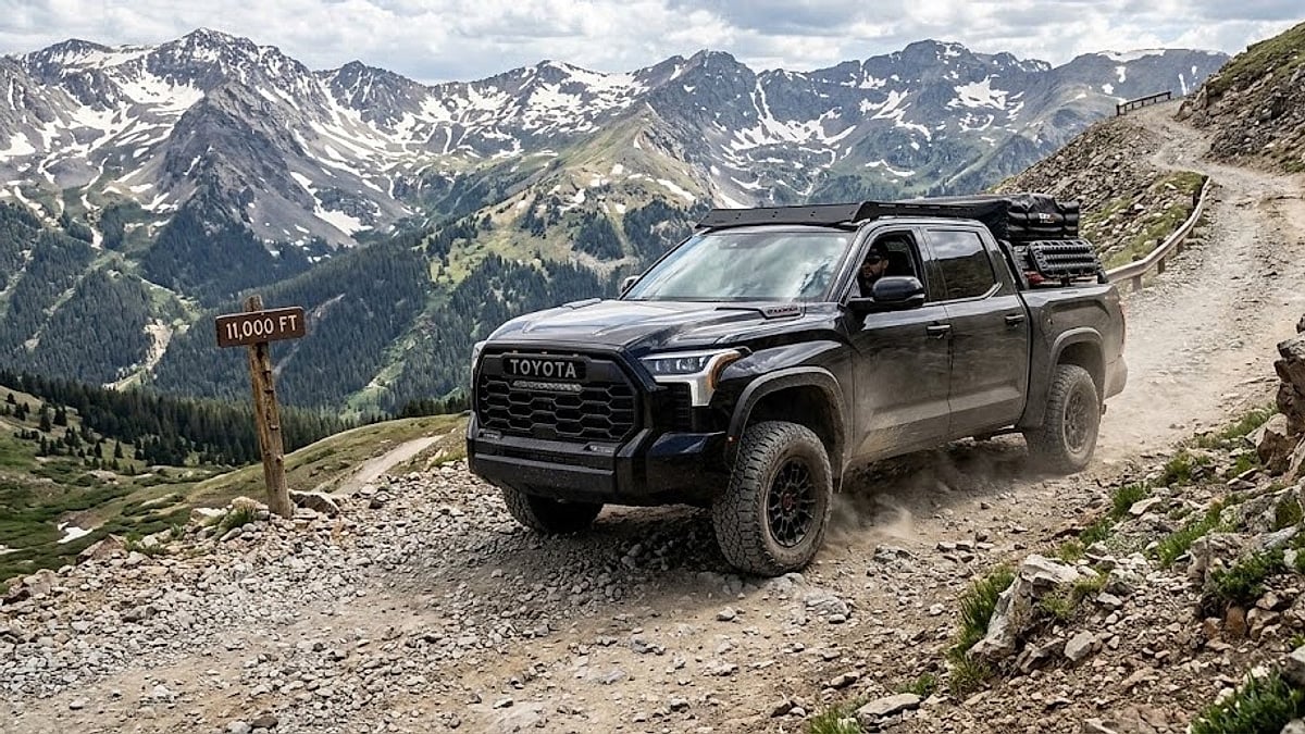A black Toyota Tundra TRD Pro truck conquers a rugged, steep mountain trail at high altitude, kicking up trail dust
