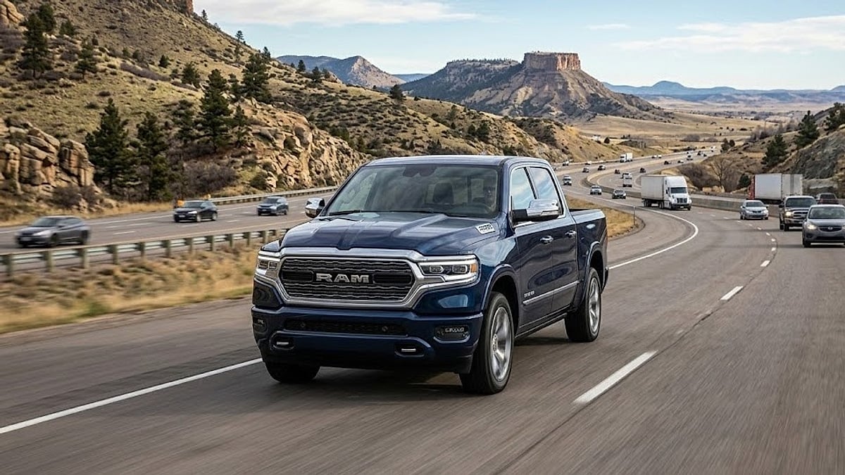 A blue 2026 Ram truck travels along Interstate 25 in Colorado, with the iconic Castle Rock rock formation visible behind