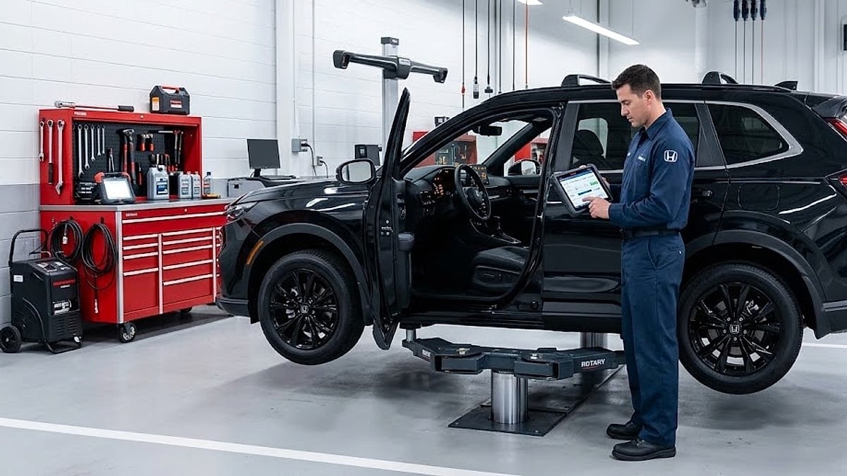 A certified automotive technician uses an advanced diagnostic scan tool on a brand-new black 2026 Honda CR-V Sport Touring