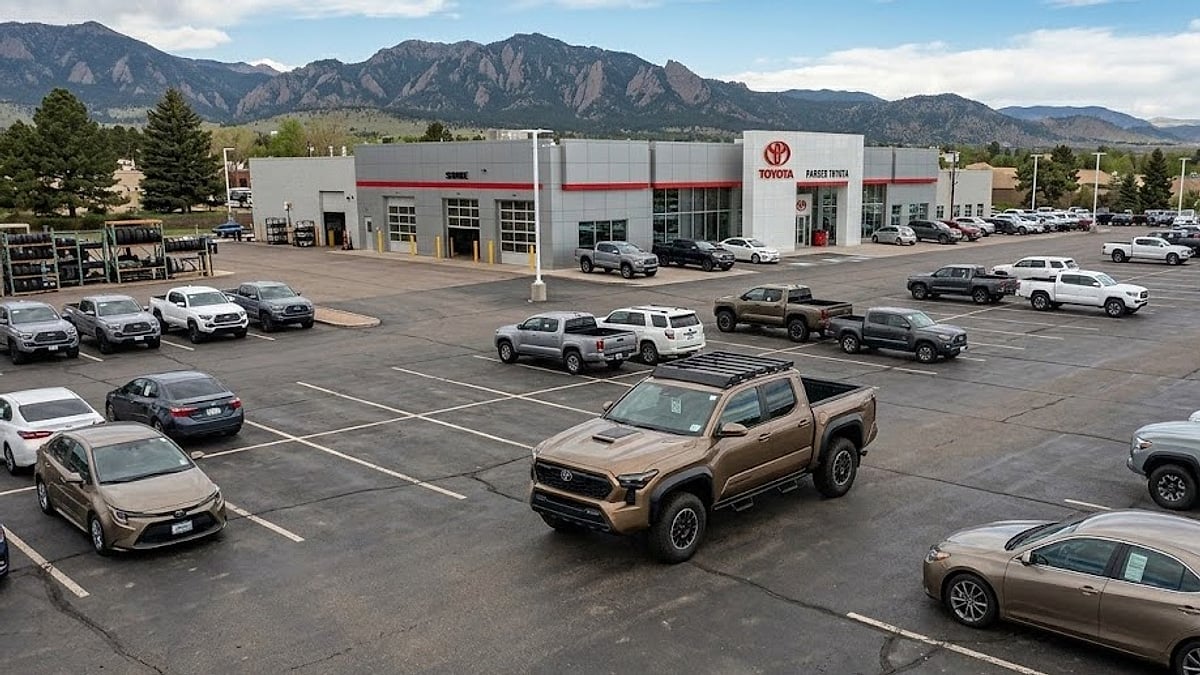 A fourth-generation Toyota Tacoma sits parked on a sparse dealership service lot awaiting backordered drivetrain components for repair