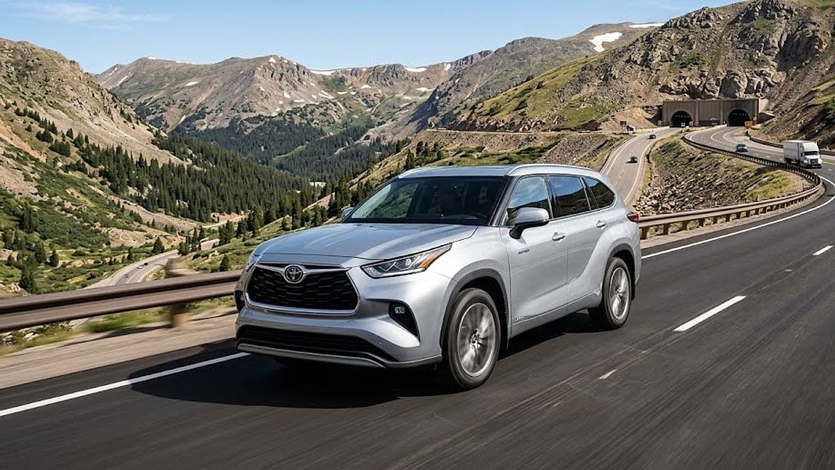 A silver 2024 Toyota Highlander climbs the steep mountain highway toward the Colorado Eisenhower Tunnel, showcasing real-world high-altitude performance