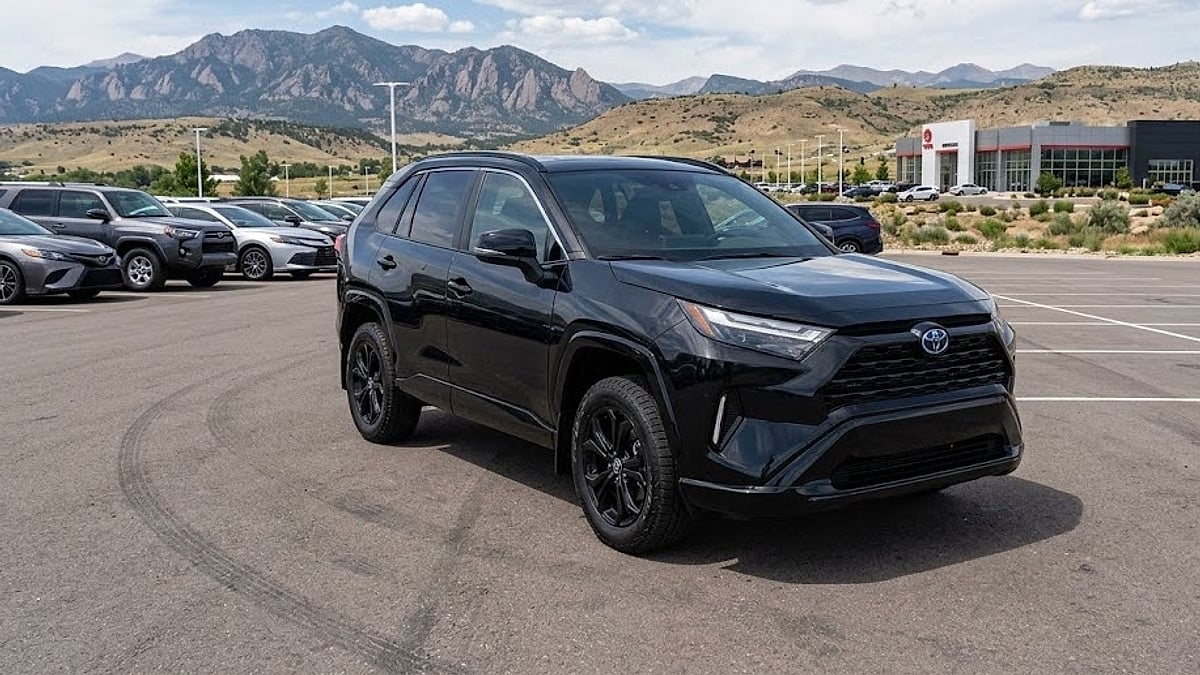 A sleek 2026 Toyota RAV4 Hybrid sits on a Parker, Colorado dealership lot, displaying its rugged high-riding stance and suspension architecture