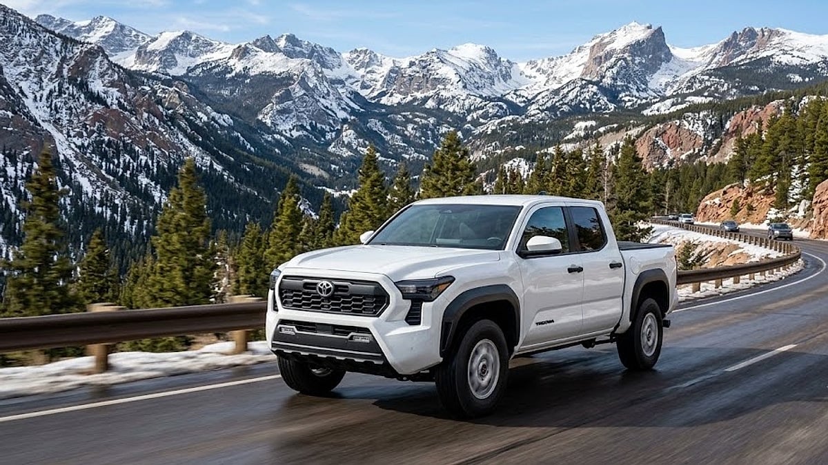 A white 2025 Toyota Tacoma SR5 driving through the scenic, high-altitude mountain passes of Colorado during the day