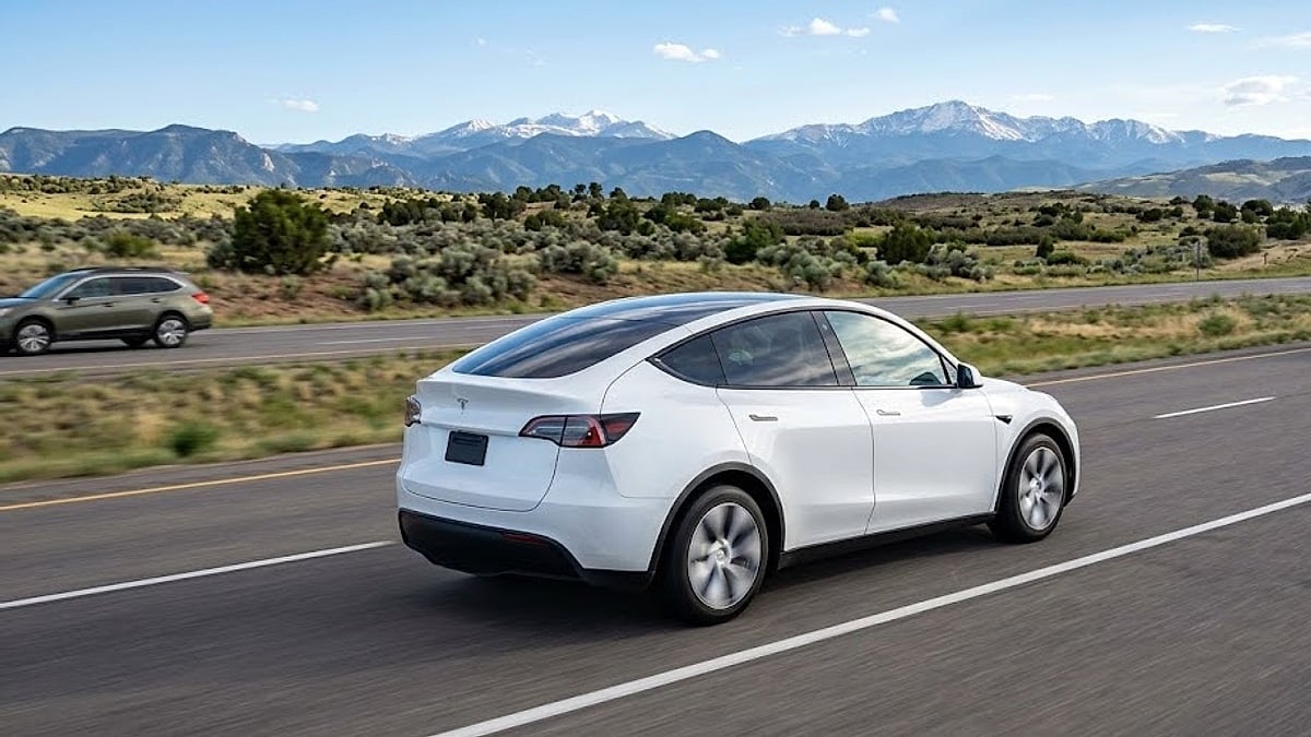 A white 2026 Tesla Model Y traverses a Colorado highway near Parker, demonstrating real-world electric vehicle chassis load limits