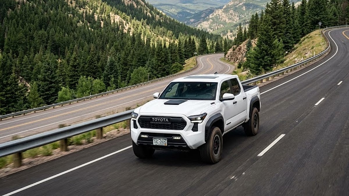 A white 2026 Toyota Tacoma TRD Pro tackles the steep, curving mountain asphalt of Colorado’s Floyd Hill highway corridor