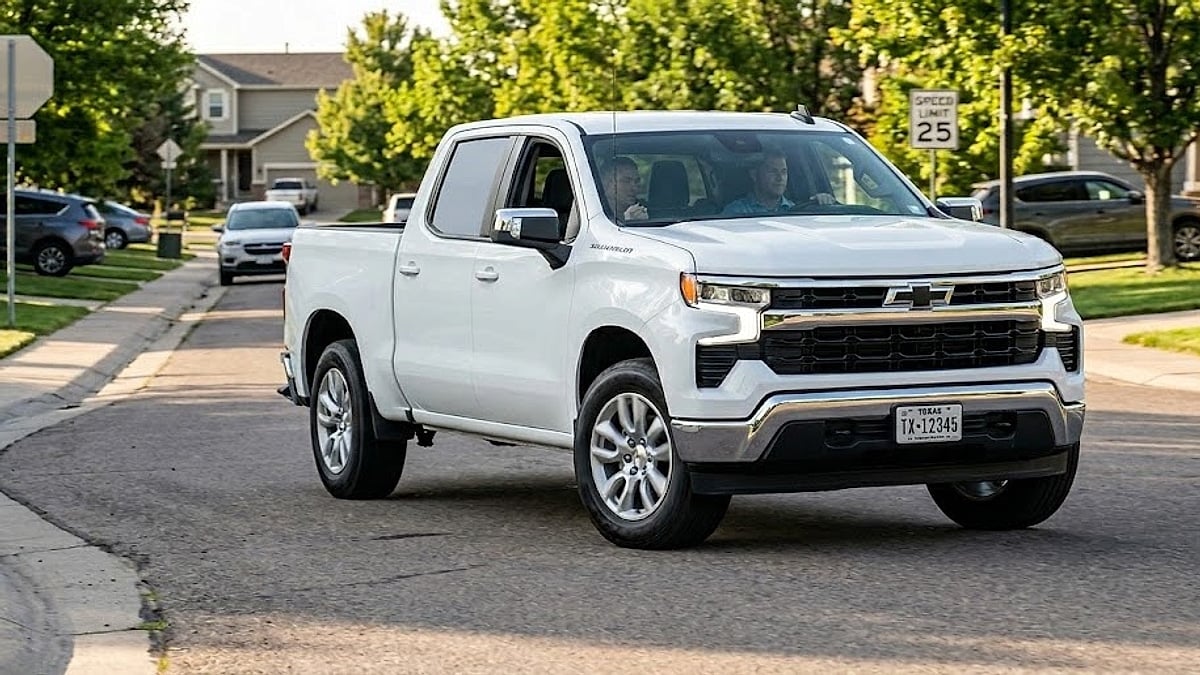 A white Chevrolet Silverado drives through a suburban neighborhood on a sunny afternoon test drive