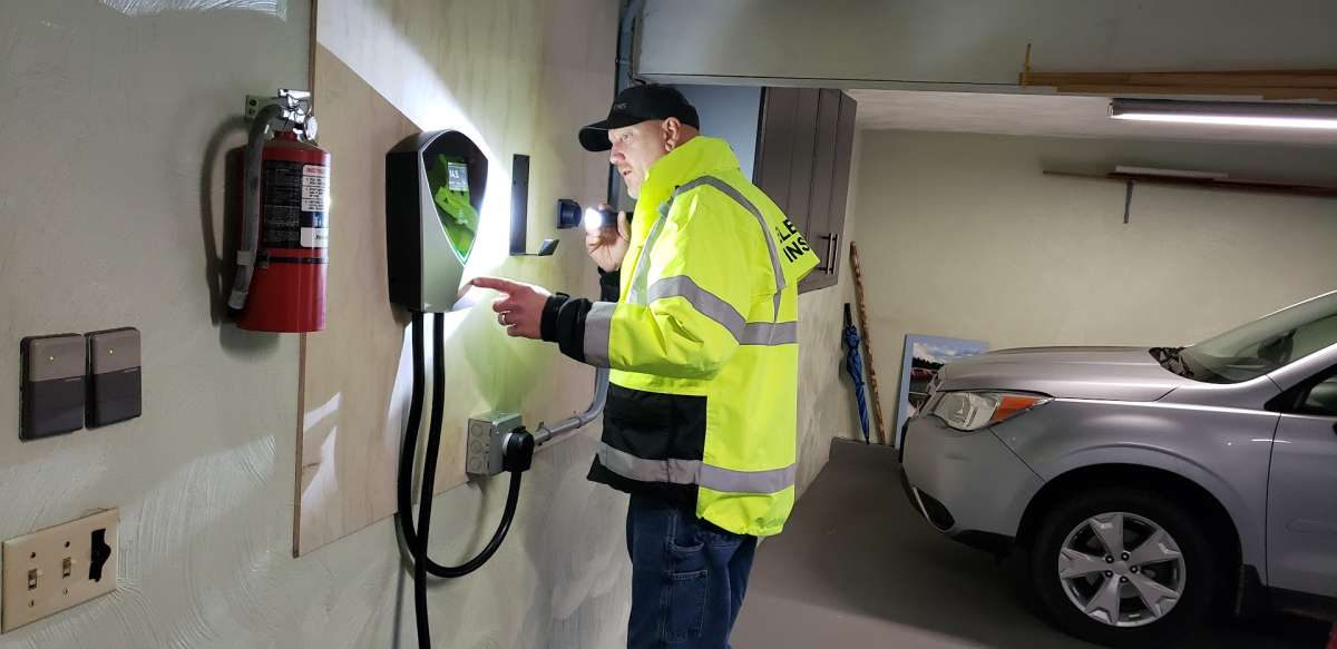 An electrical inspector looks over an EV charger install job. 