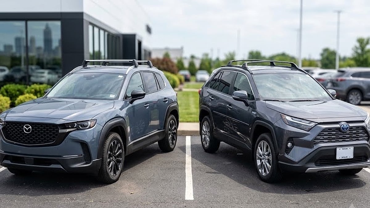 An dealership lot showcasing a Mazda CX-50 Hybrid and a Toyota RAV4 Hybrid parked side-by-side